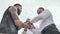 Three brutal men with a beard greet each other with a handshake.