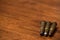 Three bullets laying on wooden background