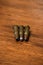 Three bullets laying on wooden background