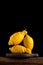 Three bumpy lemons on a black background, close-up, place for text. The trend is eating ugly fruits