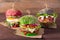 Three burgers with different bread buns on wood background
