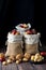 Three burlap sacks filled with mixed nuts in shells against a dark background.