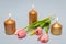 Three burning brown candles with a bouquet of pink tulips