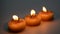 Three burning decorative candles with star pattern