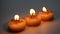 Three burning decorative candles with star pattern