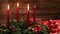 Three burning red candles on a traditional advent wreath with festive decoration