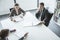 Three business people sitting around a table and having a business meeting, high angle view