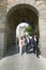 Three business people walk through gate of walled city, Avila Spain, an old Castilian Spanish village