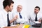 Three businessman sitting at table during meeting