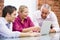 Three businesspeople in office with laptop