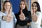 Three businesswoman are showing thumbs up gesture