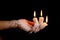Three candle sticks on fingers buring