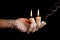 Three candle sticks on fingers buring smoulder