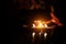 Three candles on a black background with a fireplace flame