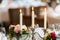 Three candles in a candle holder on decorated table