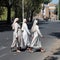 Three catholic black nuns crossing the street in Rome