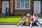 Three Caucasian women and a dog go on a trip. The girls are sitting on the curb with suitcases and waiting for a taxi