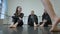 Three Caucasian young women sitting on floor watching at barefoot legs of dancer moving in slow motion. Slim charming