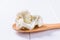 Three cauliflower inflorescences in a wooden spoon on a white table