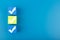 Three checkmarks on blue and yellow cubes against blue background with copy space