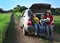 Three cheerful child sitting in the trunk of a car