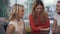 Three cheerful girls sitting at boardroom table during a break in a business meeting.