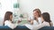 Three cheerful girls sitting on sofa with cups.