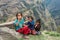 Three cheerful little girls play on the edge of the mountain road on March 28, 2018 in Nepal.