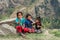 Three cheerful little girls play on the edge of the mountain road on March 28, 2018 in Nepal.