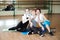 Three cheerful sportswomen laughing and having fun after workout in the gym. Cute female take a rest after hard physical