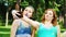 Three cheerful young women in Holi paints make funny faces for selfie photo