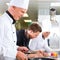 Three chefs in team in hotel or restaurant kitchen