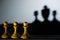 Three chess pawn with one casting a king piece shadow in dark concept of strength & aspirations