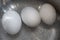 Three chicken eggs in boiling water with bubbles