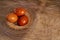 Three chicken orange Easter eggs, painted onion husks in a wicker basket on a brown cloth in the rustic style