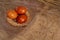 Three chicken orange Easter eggs, painted onion husks in a wicker basket on a brown cloth in the rustic style