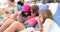 Three child girls with tablet on beach lie in sun lounger