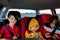 Three children, boys, traveling in car in carseat and playing on mobiles