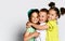 Three children in bright clothes, two girls and one boy. Triplets, brother and sisters. hugging on camera. Family ties, friendship