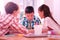 Three children drawing a school project together.