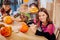 Three children feeling involved in decorating pumpkins for Halloween party