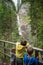 Three children leaning on wooden fence looking at a beautiful Martuljek waterfall