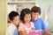 Three children look at a tablet computer