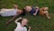 Three Children Lying On Grass. Looks Like Beautiful Summer Sunny Day.
