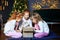 Three children open a gift box. Sisters in pajamas. The concept of Merry Christmas, holidays, New Year, family and gifts