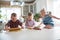 Three children preparing cookies in the kitchen