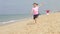 Three Children Running Along The Beach Together