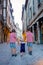 Three children, siblings, boys, walking hand in hands on the street of town of Dijon