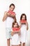 Three children in the studio stand on a white background and eat pieces of watermelon and laugh