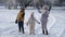 Three children throws snow up in the air